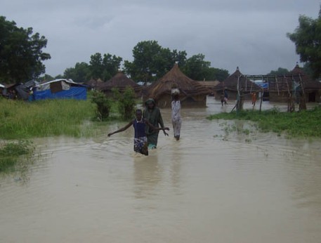Bor flood victims wade through a lake of flood plains in Bor town.